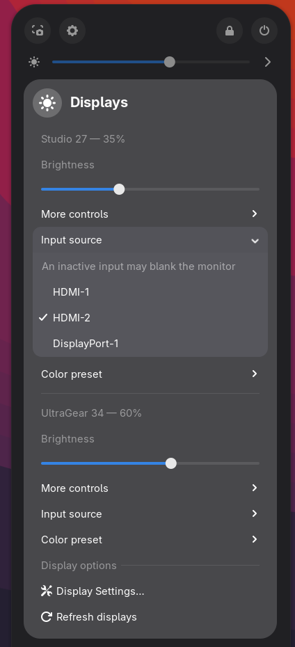 Input source geopend voor één monitor: een waarschuwing dat een inactieve ingang de monitor zwart kan maken, daarna HDMI-1, HDMI-2 (gekozen) en DisplayPort-1